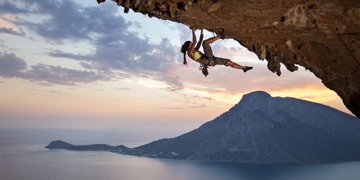 Junge Frau klettert im Sonnenuntergang auf Kalymnos