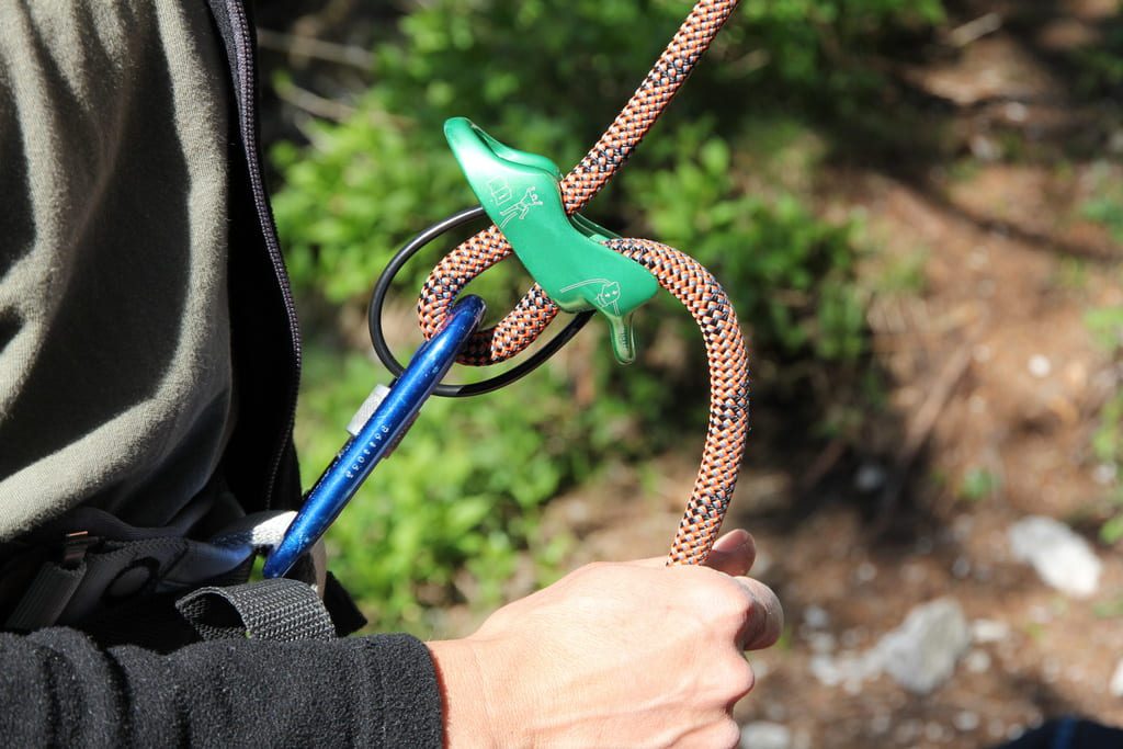 Kletterausrüstung: Seil im Sicherungsgerät für sicheres Klettern Kletterer hält ein Kletterseil im Sicherungsgerät – zentrale Ausrüstung für Sicherheit, Schutz und Effizienz beim Klettern