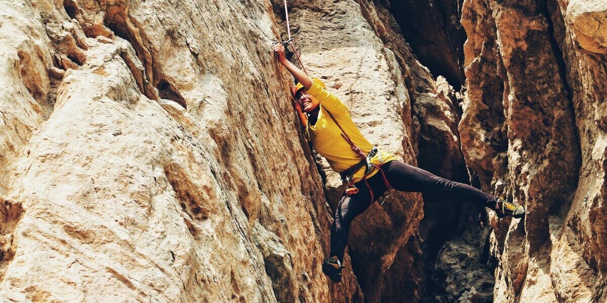 Kletterer klettert mit Kletterbekleidung in schwieriger Route.